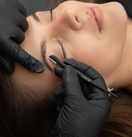 Un mannequin allongé se faisant couper le front avec un rasoir à sourcils