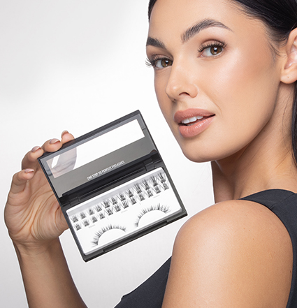 Femme blonde tenant des kits d'extension de cils
